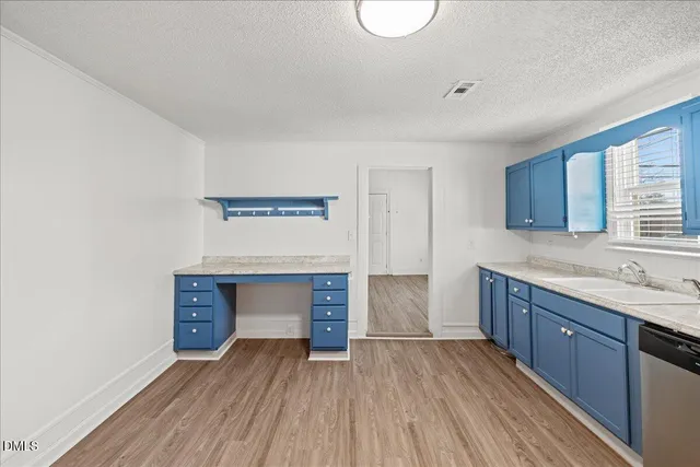 a kitchen with a sink and wooden floor