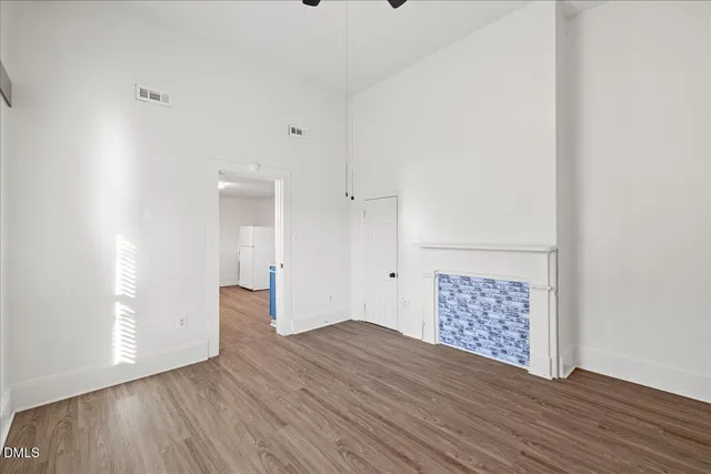 a view of empty room with wooden floor