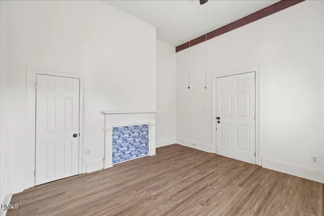 a view of an empty room with wooden floor