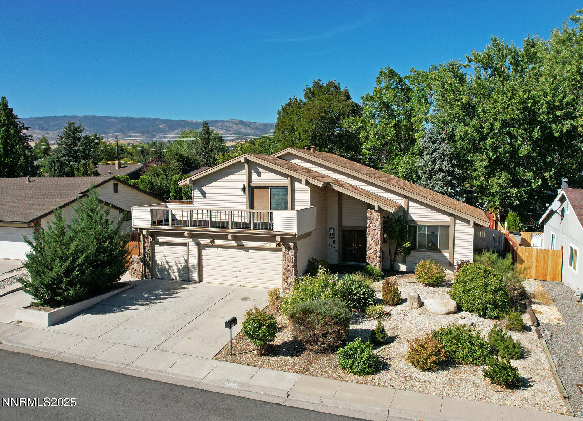 4875 Golden Springs Drive Reno, NV 89509 - Photo 1 of 33 a view of a white house with a flower garden in front of it