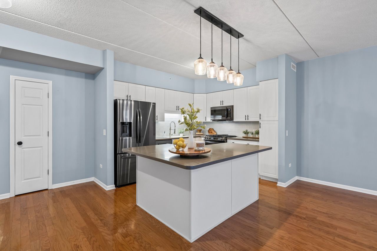 133 West Palatine Road, Unit 108 Palatine, IL 60067 - Photo 12 of 37 a kitchen with kitchen island stainless steel appliances a center island a sink cabinets and wooden floor