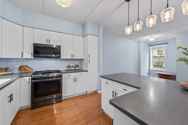 a kitchen with stainless steel appliances granite countertop a stove a microwave and a refrigerator