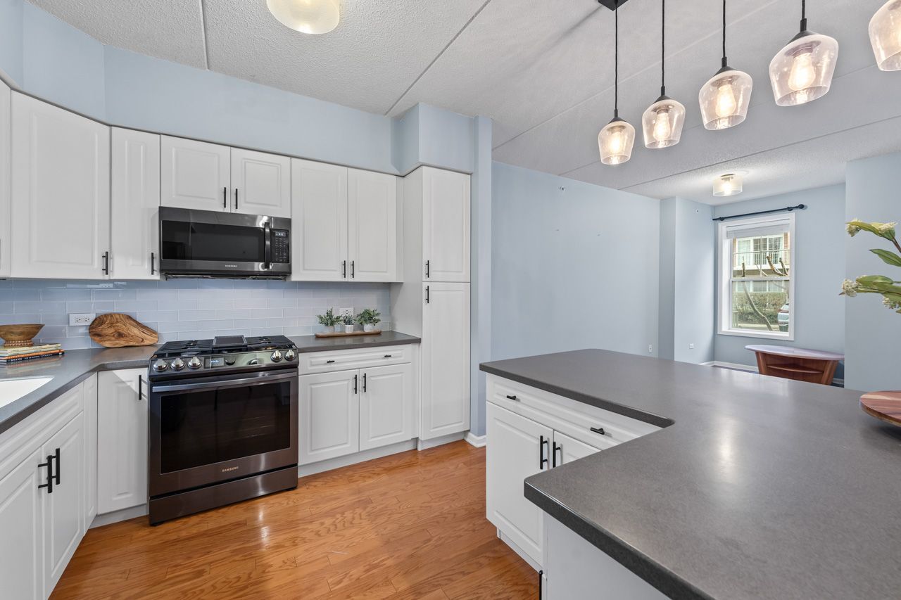133 West Palatine Road, Unit 108 Palatine, IL 60067 - Photo 16 of 37 a kitchen with stainless steel appliances granite countertop a stove a microwave and a refrigerator