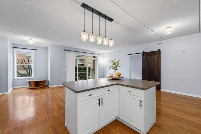a kitchen with stainless steel appliances granite countertop a sink a stove and a wooden floors