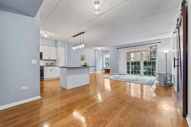 a view of large kitchen with cabinets and wooden floor