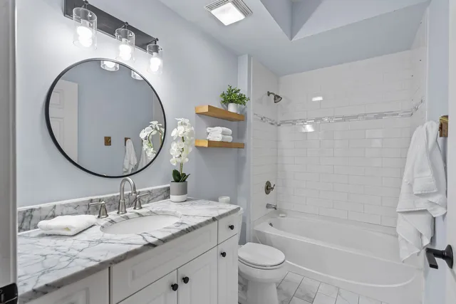 a bathroom with a granite countertop sink toilet and a mirror