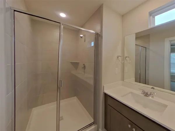 a bathroom with a shower sink vanity and mirror
