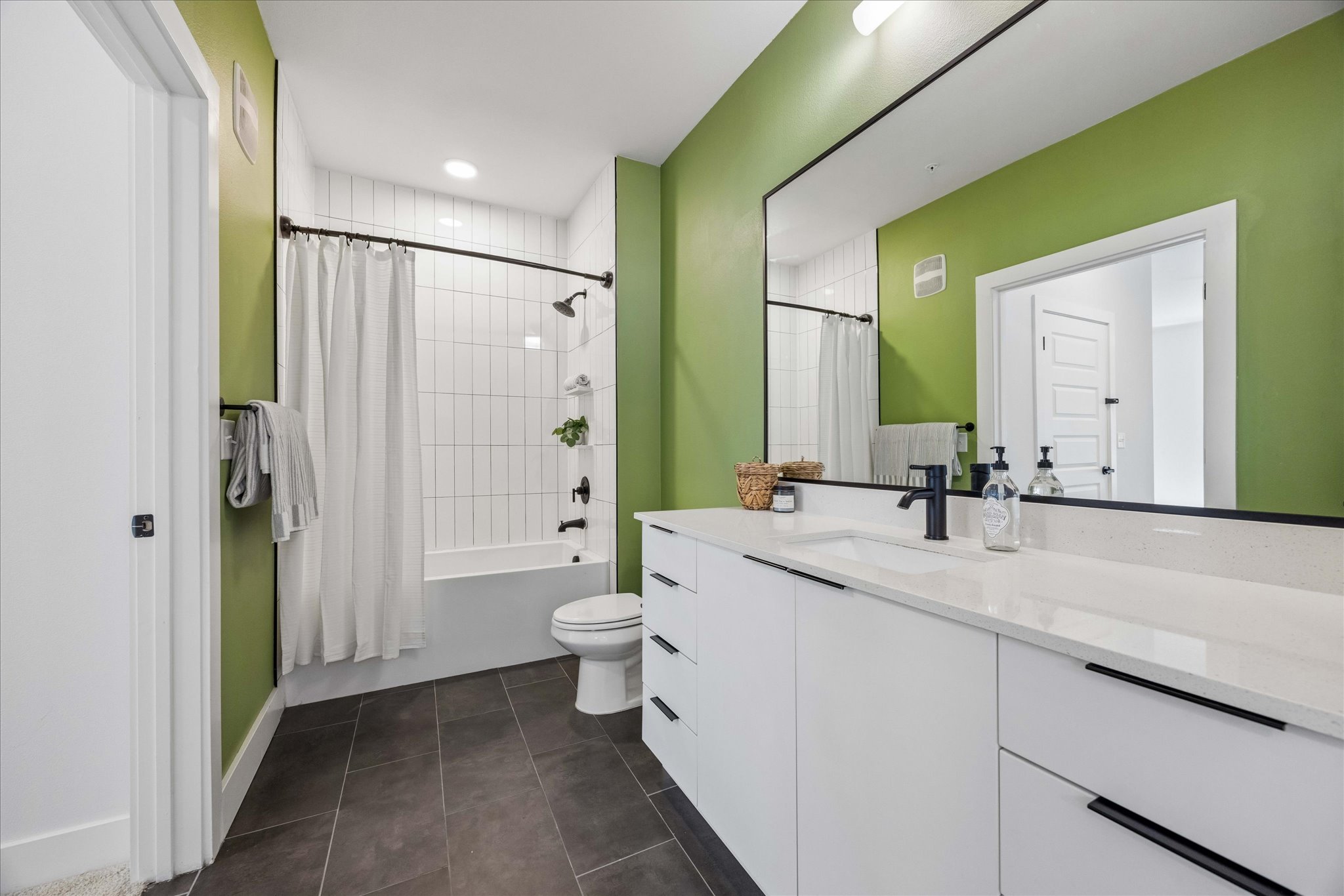 2220 Webberville Road, Unit 216 Austin, TX 78702 - Photo 14 of 26 Bathroom featuring a spacious vanity with white cabinetry, a light-toned countertop, and a large mirror