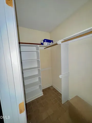 a view of walk in closet with empty racks