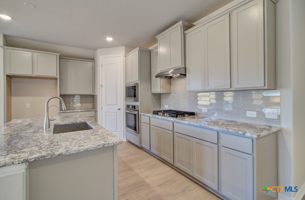 2118 Shepard Street Seguin, TX 78155 - Photo 4 of 24 a kitchen with stainless steel appliances granite countertop a sink stove and refrigerator