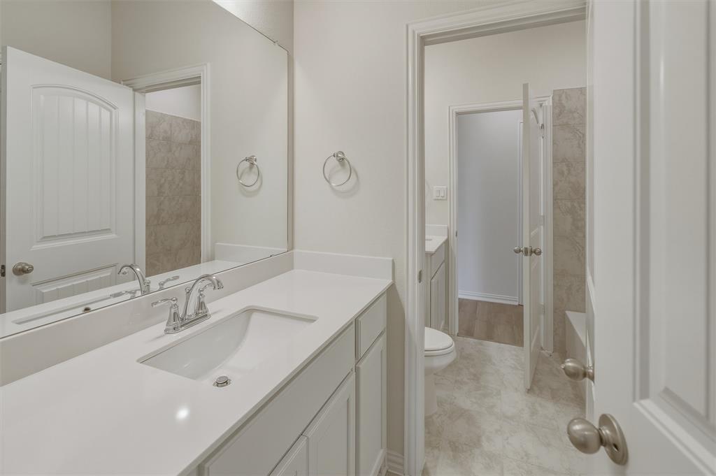 1217 Colca Drive Springtown, TX 76082 - Photo 16 of 25 Double vanity with integrated sinks, chrome fixtures, and a full-width mirror