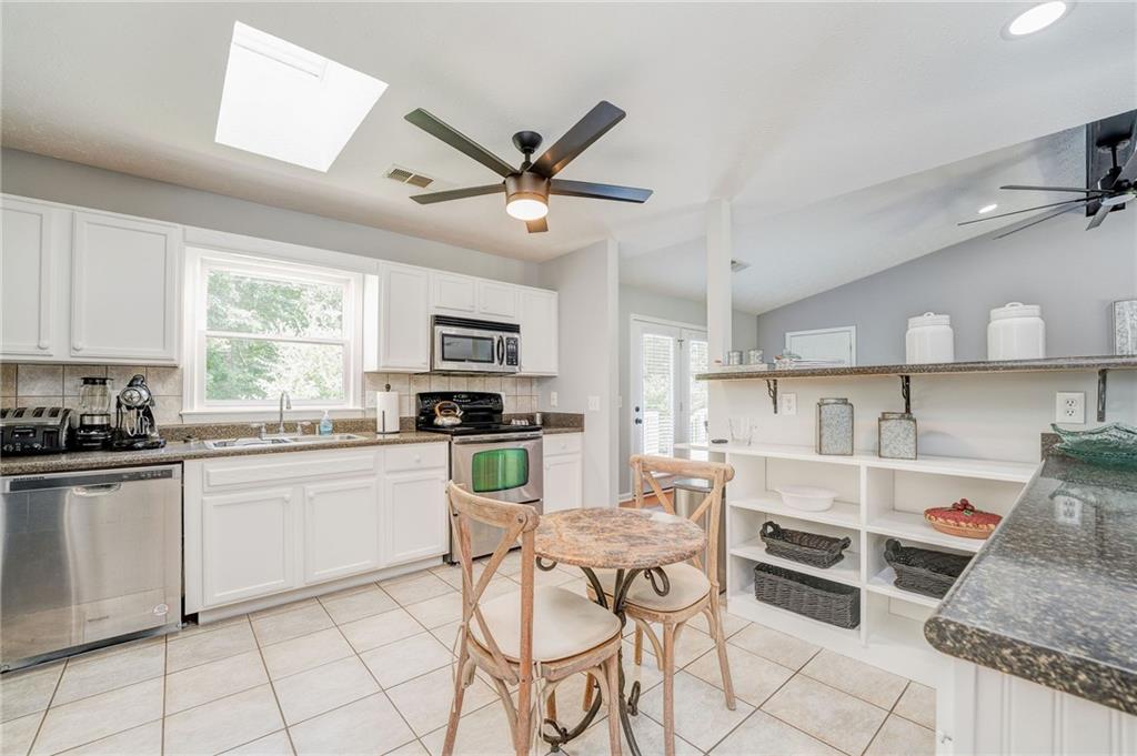 41 Summit Ridge Drive Southeast Cartersville, GA 30120 - Photo 11 of 43 a kitchen with stainless steel appliances granite countertop a stove top oven a sink dishwasher and white cabinets with wooden floor