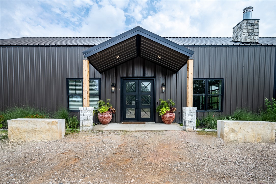 a view of a house with large windows and a table and chairs