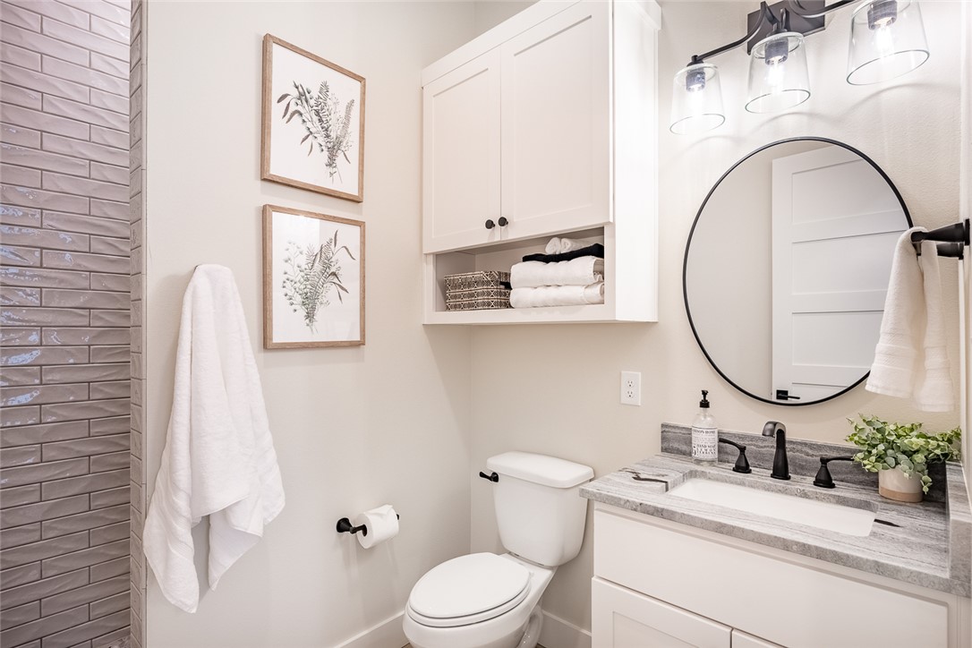 6876 Koppe Bridge Road College Station, TX 77845 - Photo 17 of 23 a bathroom with a granite countertop toilet sink and mirror