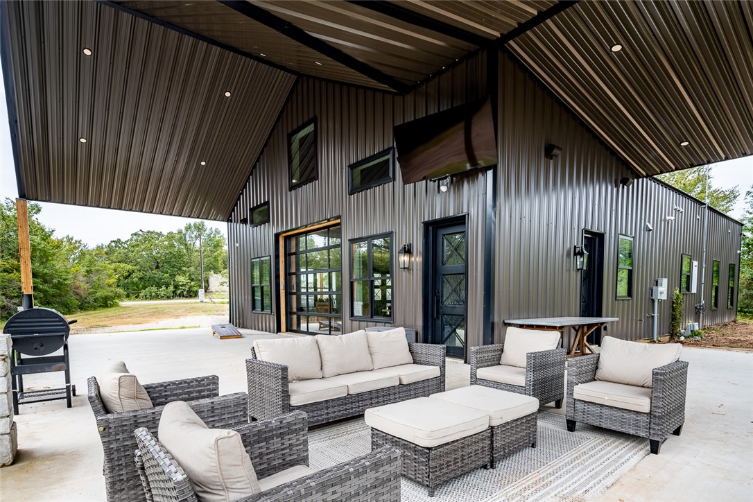 6876 Koppe Bridge Road College Station, TX 77845 - Photo 21 of 23 a view of a patio with couches and table and chairs with wooden floor and fence