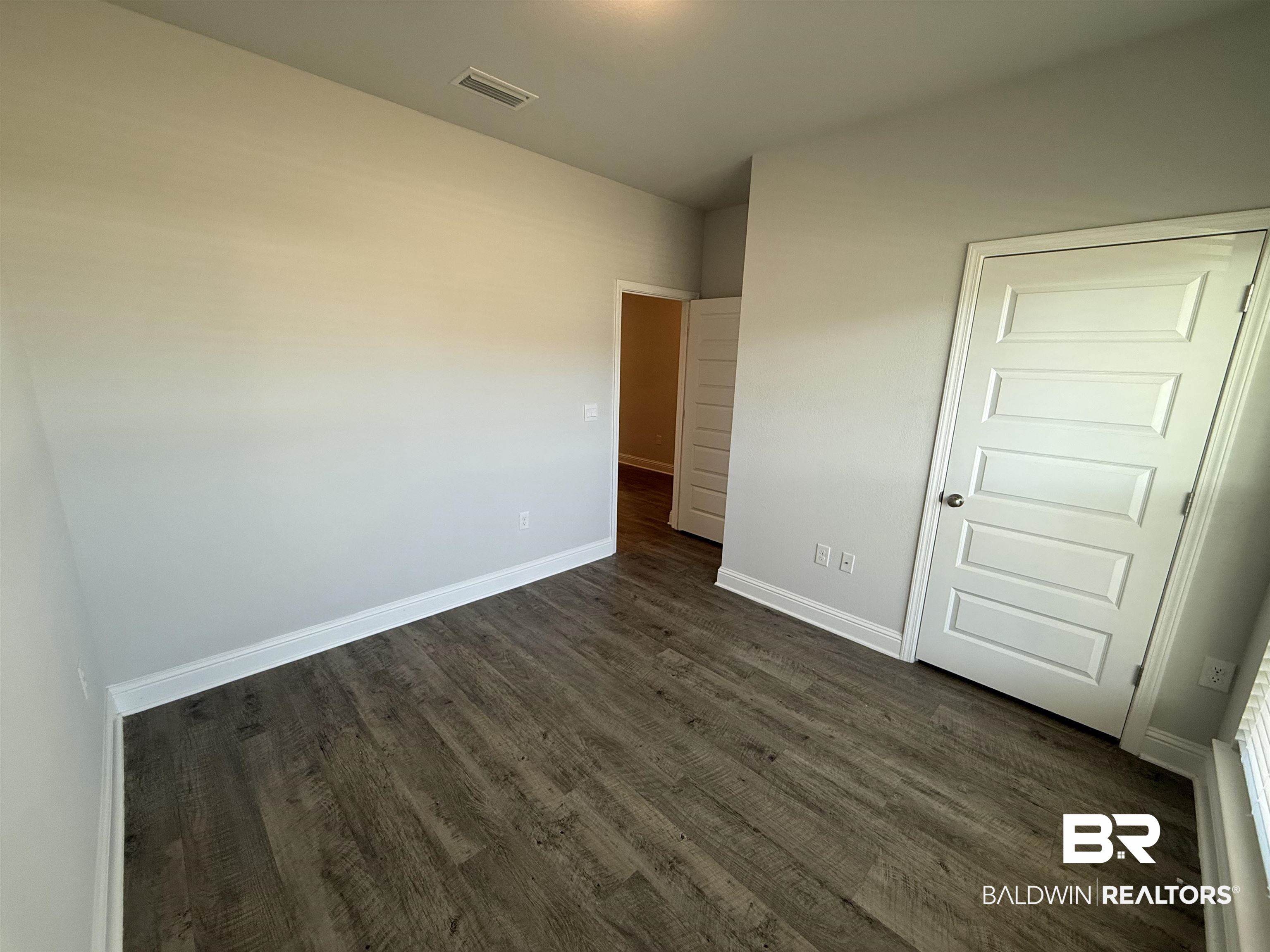 23247 Lieutenant Avenue Foley, AL 36535 - Photo 7 of 47 Interior room featuring wood-finish flooring, light gray wall paint, and crisp white trim