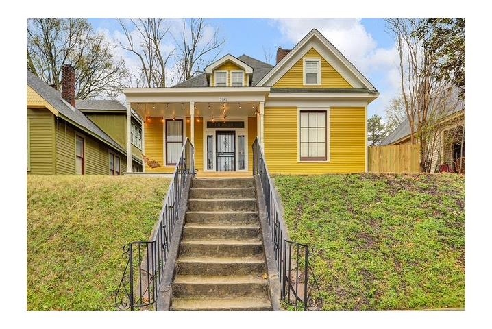 a front view of a house with a garden and plants