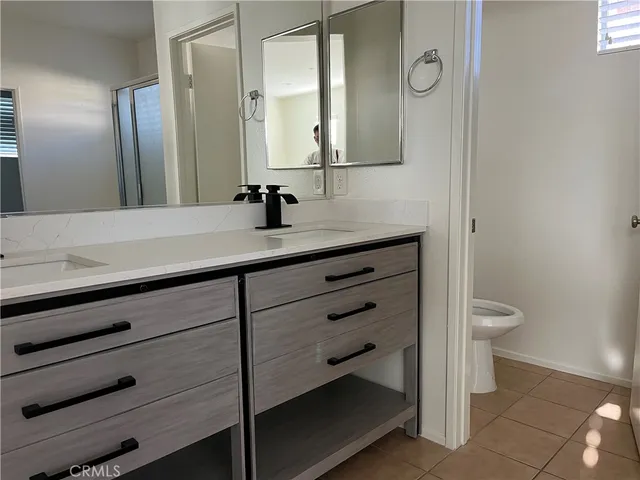 a bathroom with a sink a toilet and a mirror