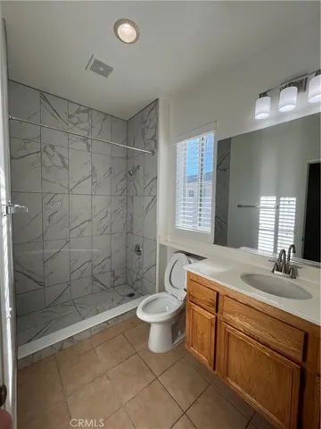 a bathroom with a granite countertop sink a toilet a mirror and shower