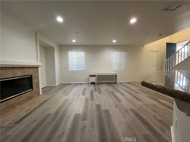 a view of empty room with wooden floor and fireplace