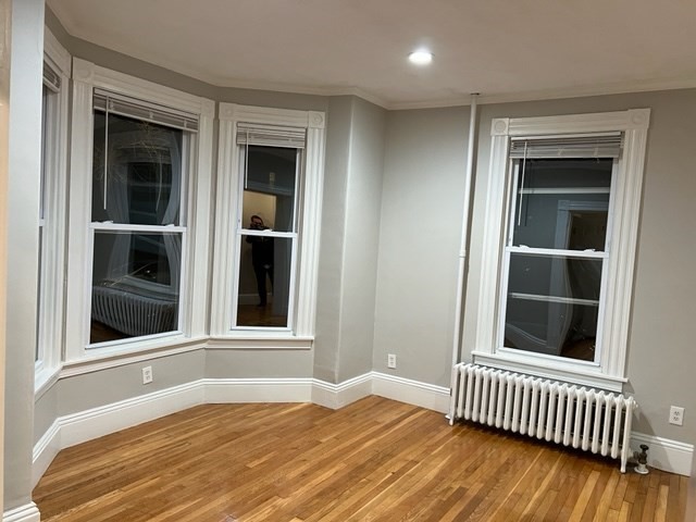 59 Spring Street, Unit 3 Wakefield, MA 01880 - Photo 2 of 5 a view of an empty room with wooden floor and a window