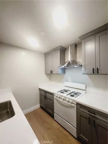 a kitchen with granite countertop a sink a stove and cabinets