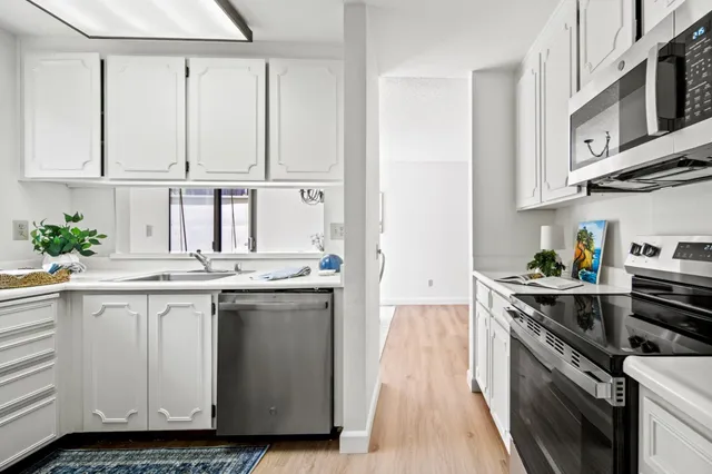 a kitchen with stainless steel appliances granite countertop a stove a sink and a refrigerator