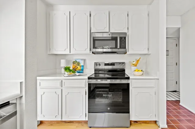 a kitchen with white cabinets and stainless steel appliances