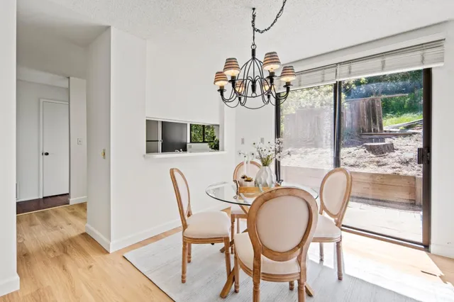 a dining room with furniture a chandelier and wooden floor
