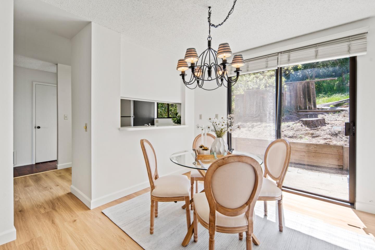 70 Forest Ridge Road, Unit 22 Monterey, CA 93940 - Photo 7 of 17 a dining room with furniture a chandelier and wooden floor