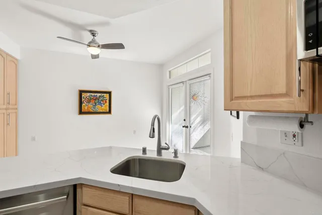 a kitchen with a sink and a stove with wooden floor