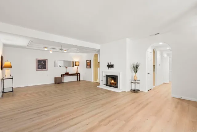 a view of empty room with wooden floor and fireplace