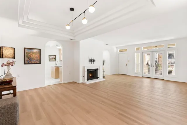 a view of a livingroom with wooden floor and a fireplace