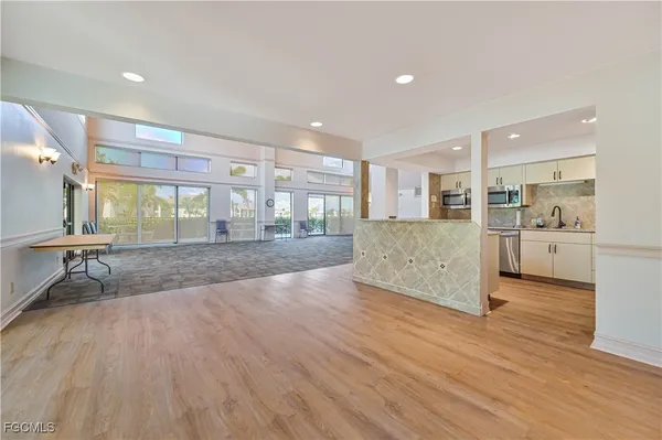 a view of a kitchen with kitchen island wooden floors wooden floor and appliances