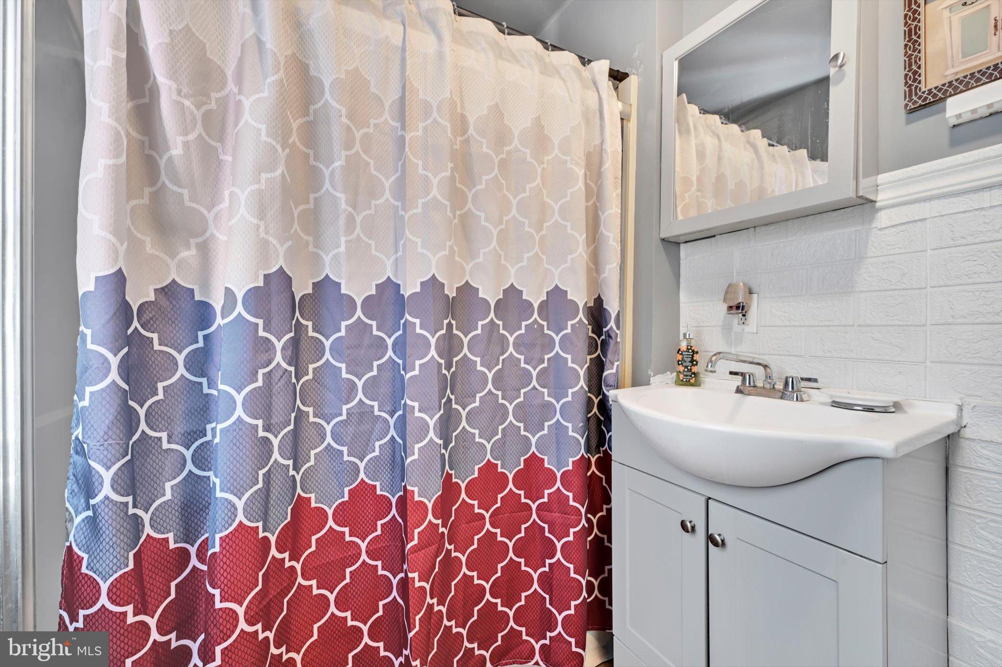 352 South Ann Street Lancaster, PA 17602 - Photo 14 of 23 a bathroom with a sink a vanity and a shower curtain