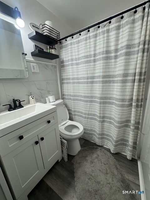 33 Westview Street Hamden, CT 06514 - Photo 10 of 11 a bathroom with a sink a toilet and shower curtain