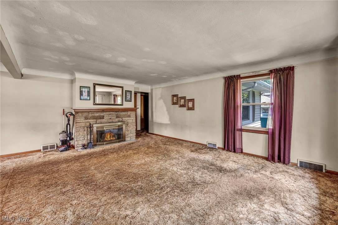 11858 Ridge Road North Royalton, OH 44133 - Photo 13 of 38 Unfurnished living room featuring a fireplace, carpet flooring, and a textured ceiling