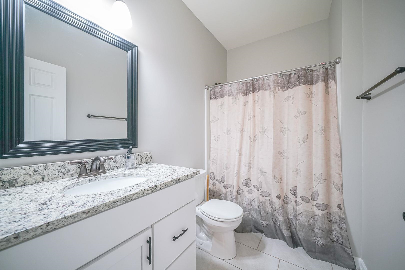 212 Martin Avenue Oregon, IL 61061 - Photo 16 of 29 a bathroom with a granite countertop sink toilet and a mirror