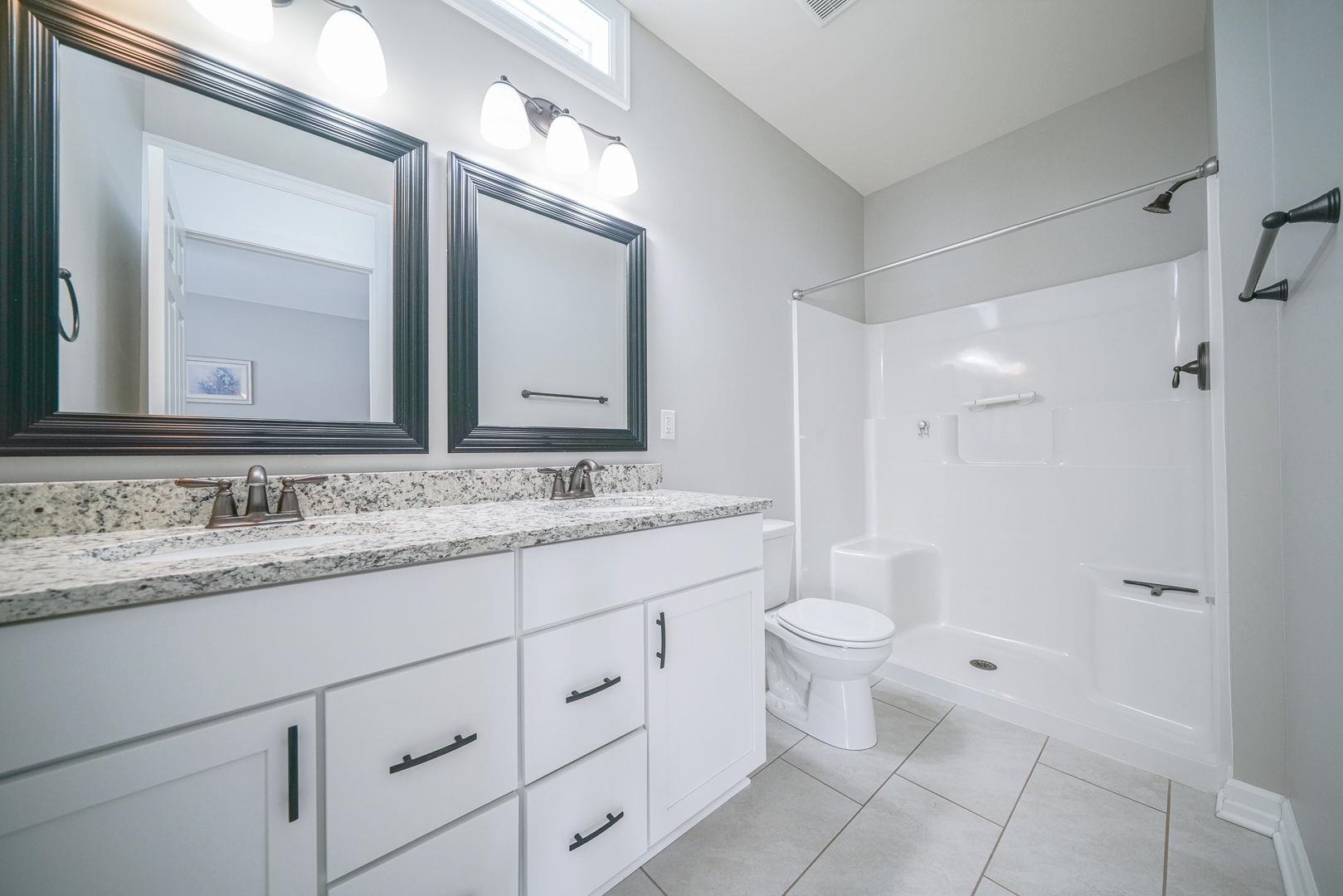 212 Martin Avenue Oregon, IL 61061 - Photo 21 of 29 a bathroom with a granite countertop toilet sink and a mirror