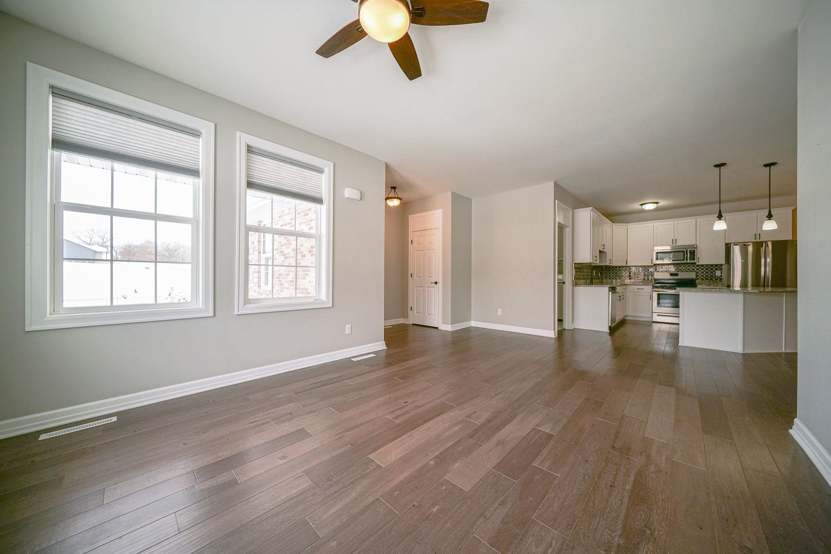 212 Martin Avenue Oregon, IL 61061 - Photo 8 of 29 an empty room with wooden floor kitchen view and windows