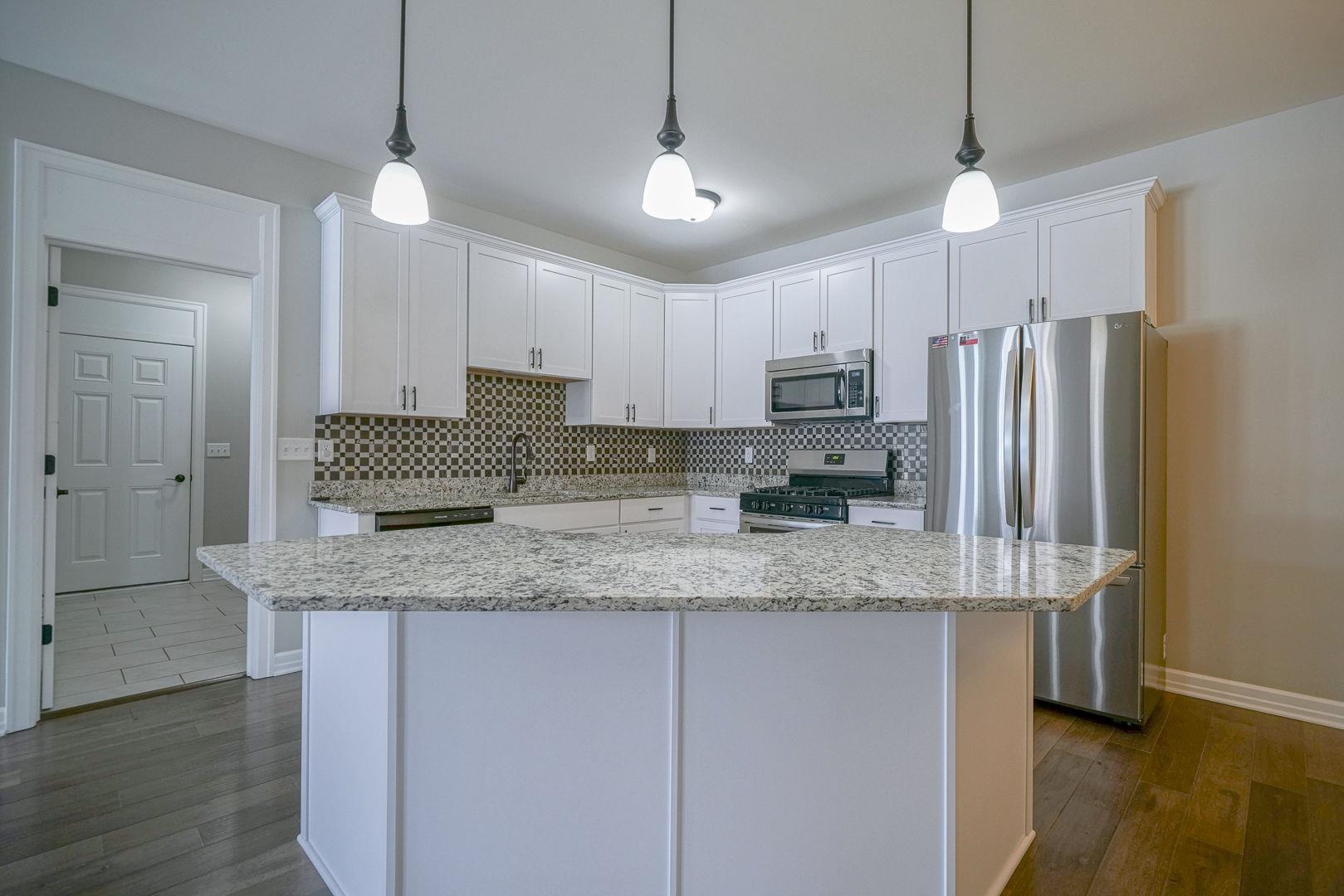 212 Martin Avenue Oregon, IL 61061 - Photo 9 of 29 a kitchen with stainless steel appliances granite countertop a sink refrigerator and microwave