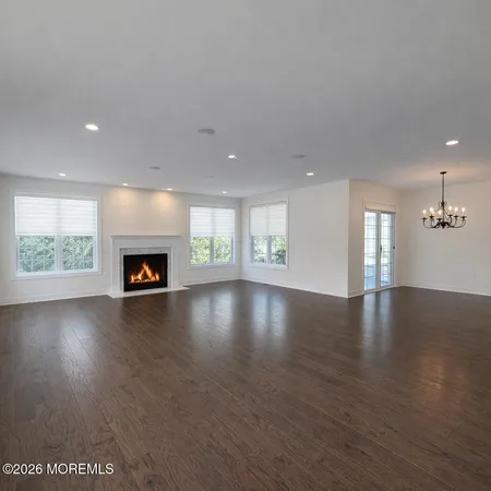 an empty room with windows fireplace and wooden floor