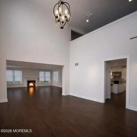 a view of empty room with wooden floor and windows