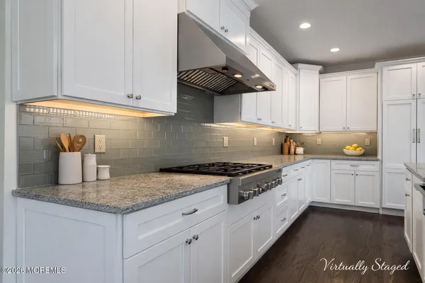 a kitchen with granite countertop a sink a stove and cabinets
