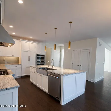 a kitchen with stainless steel appliances granite countertop a sink a stove and a refrigerator