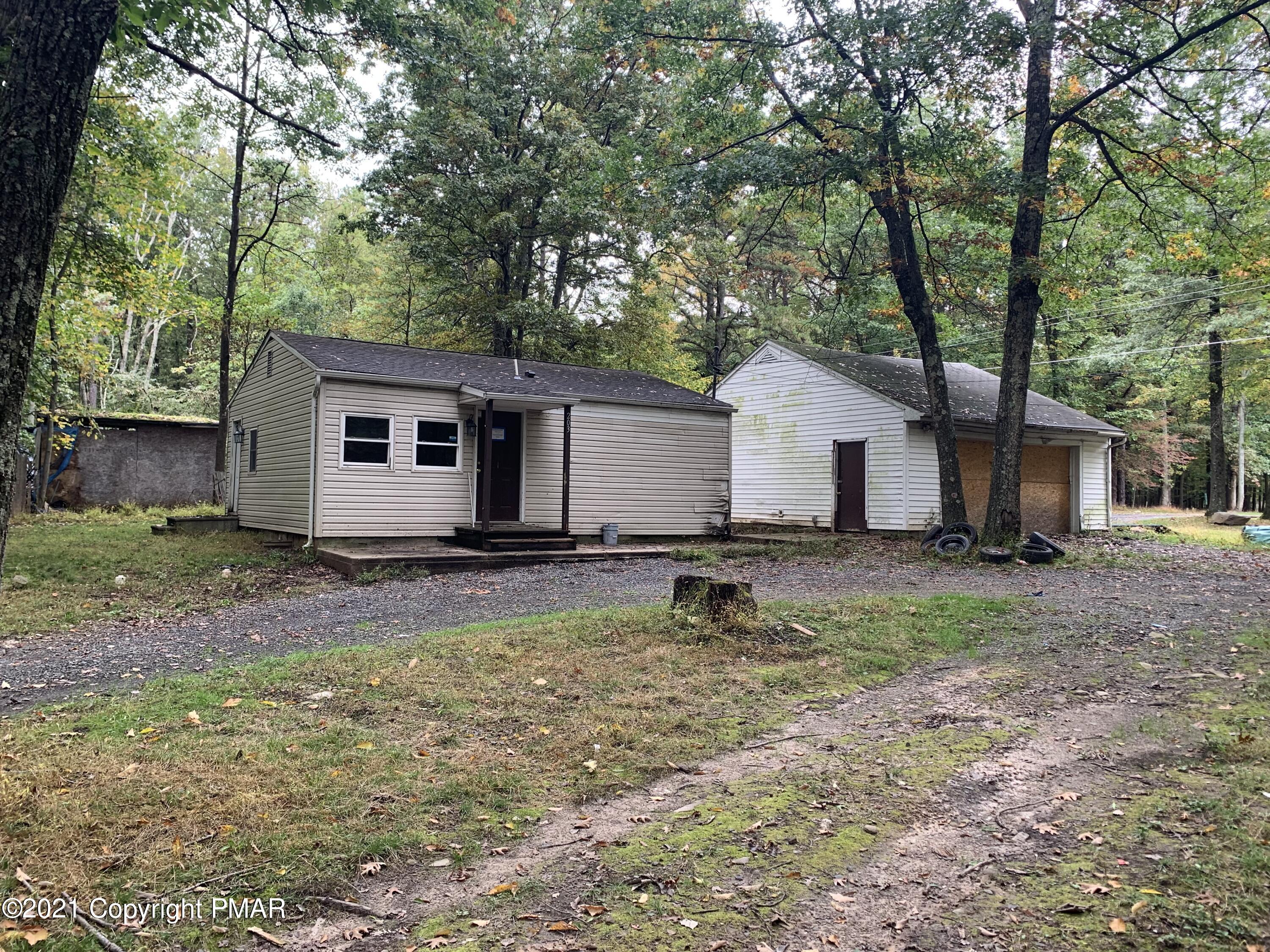 a view of a house with backyard and a tree