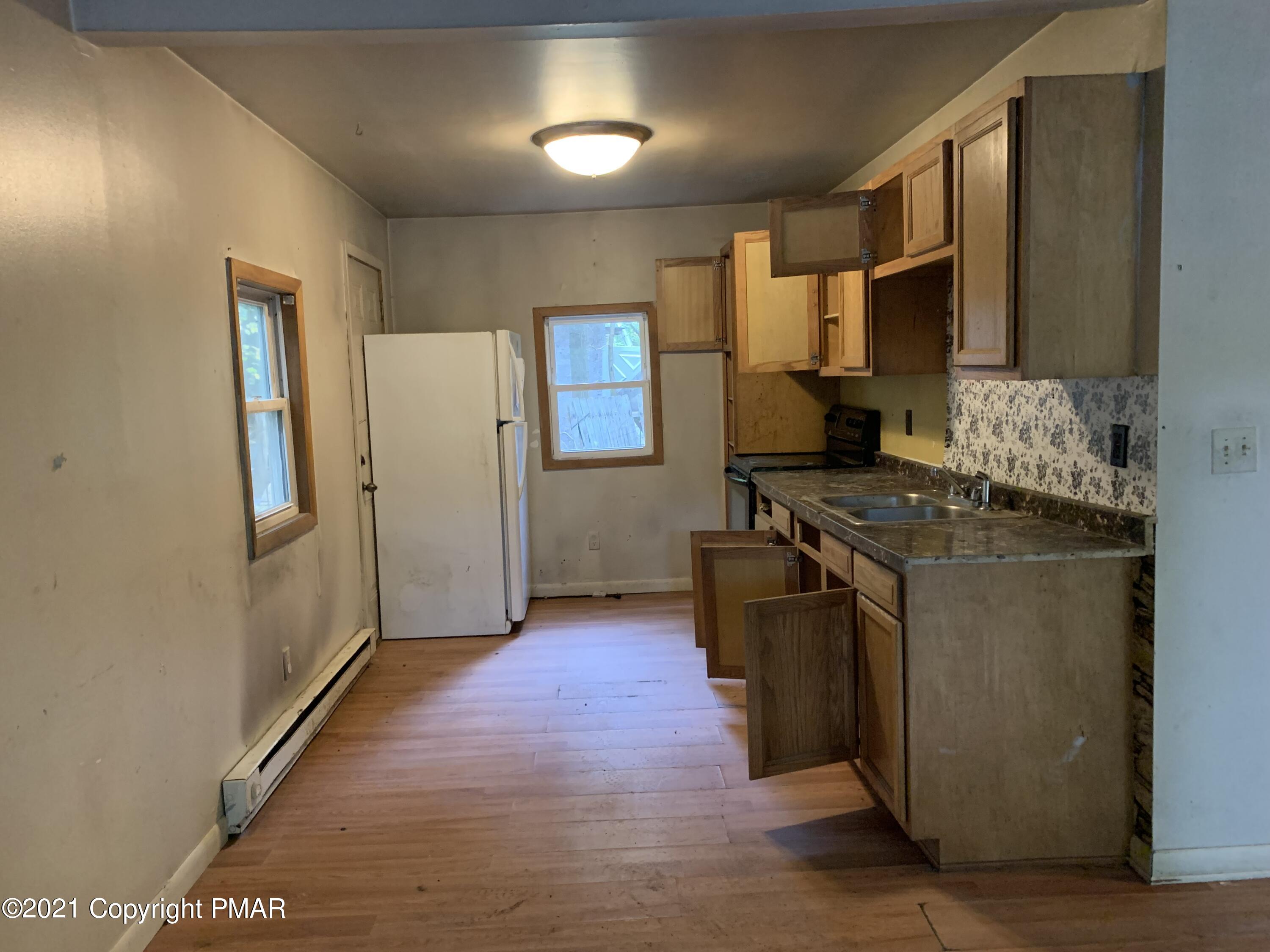 203 Semmel Road Effort, PA 18330 - Photo 8 of 18 a kitchen with stainless steel appliances granite countertop a refrigerator a stove and a sink