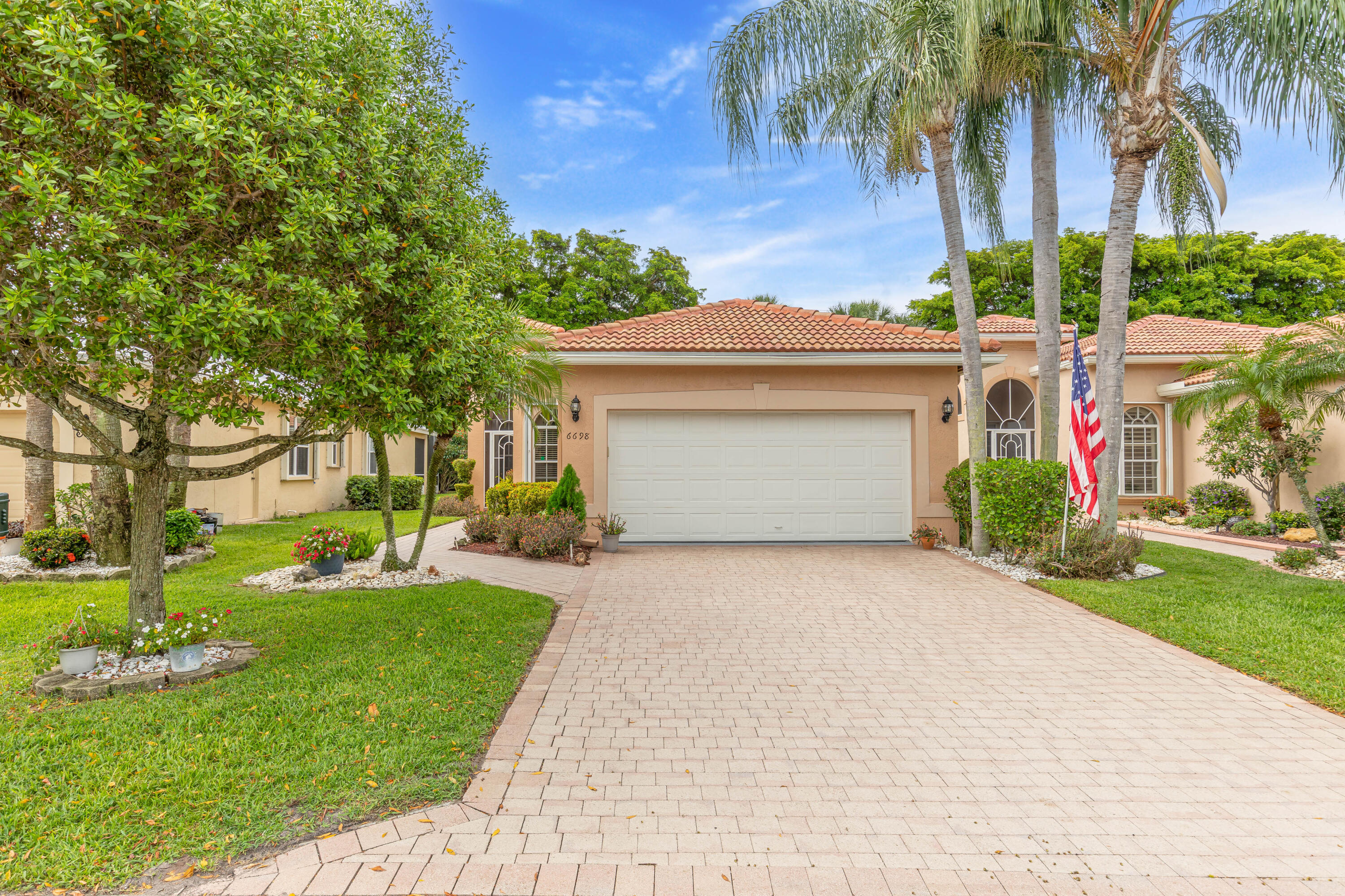 6698 Vía Roma Delray Beach, FL 33446 - Photo 4 of 50 front view of house with a yard and palm trees