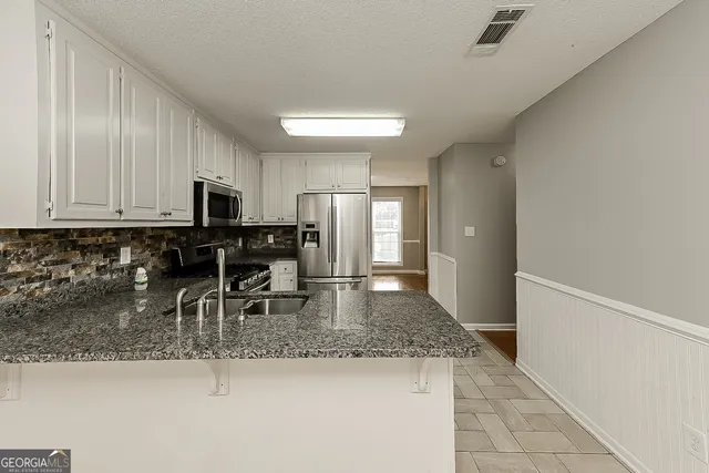 a kitchen with stainless steel appliances granite countertop a sink stove and refrigerator