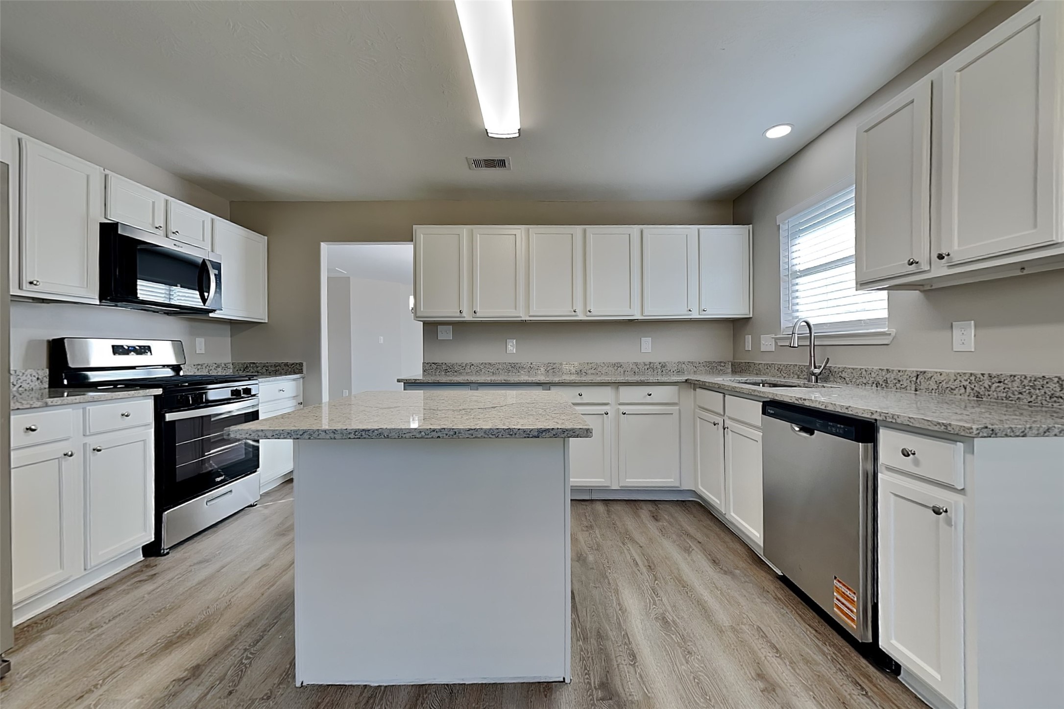 29207 Fox Fountain Lane Spring, TX 77386 - Photo 6 of 24 a kitchen with granite countertop a stove top oven a sink dishwasher and a refrigerator with wooden floor